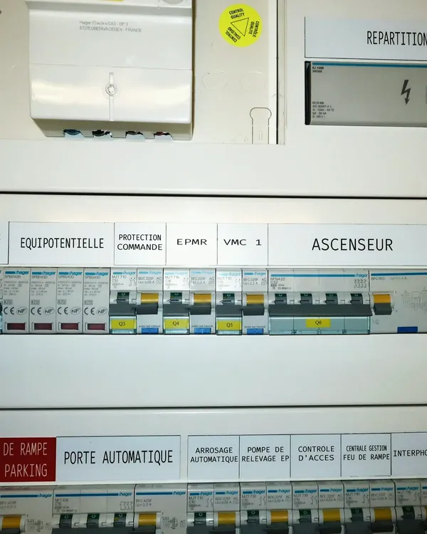 Tableau de distribution tertiaire, départs repérés : ascenseur, VMC, porte automatique.